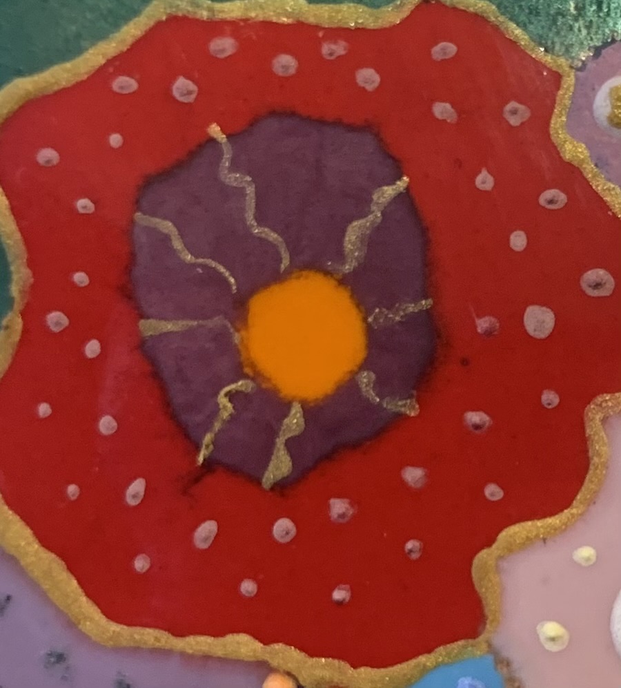 Détail d'un tableau en émaux sur cuivre représentant le cœur d'une fleur aux couleurs orange, violet et rouge réhaussé de traits dorés et de petits points roses.