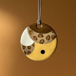 Pendentif rond en émaux sur cuivre cloisonnés aux couleurs léopard, jaune, marron et blanche.