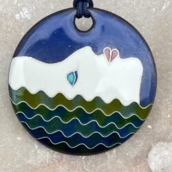 Pendentif rond en émaux sur cuivre cloisonnés. Il représente le profil dune femme qui a flotte à la surface d l'eau.