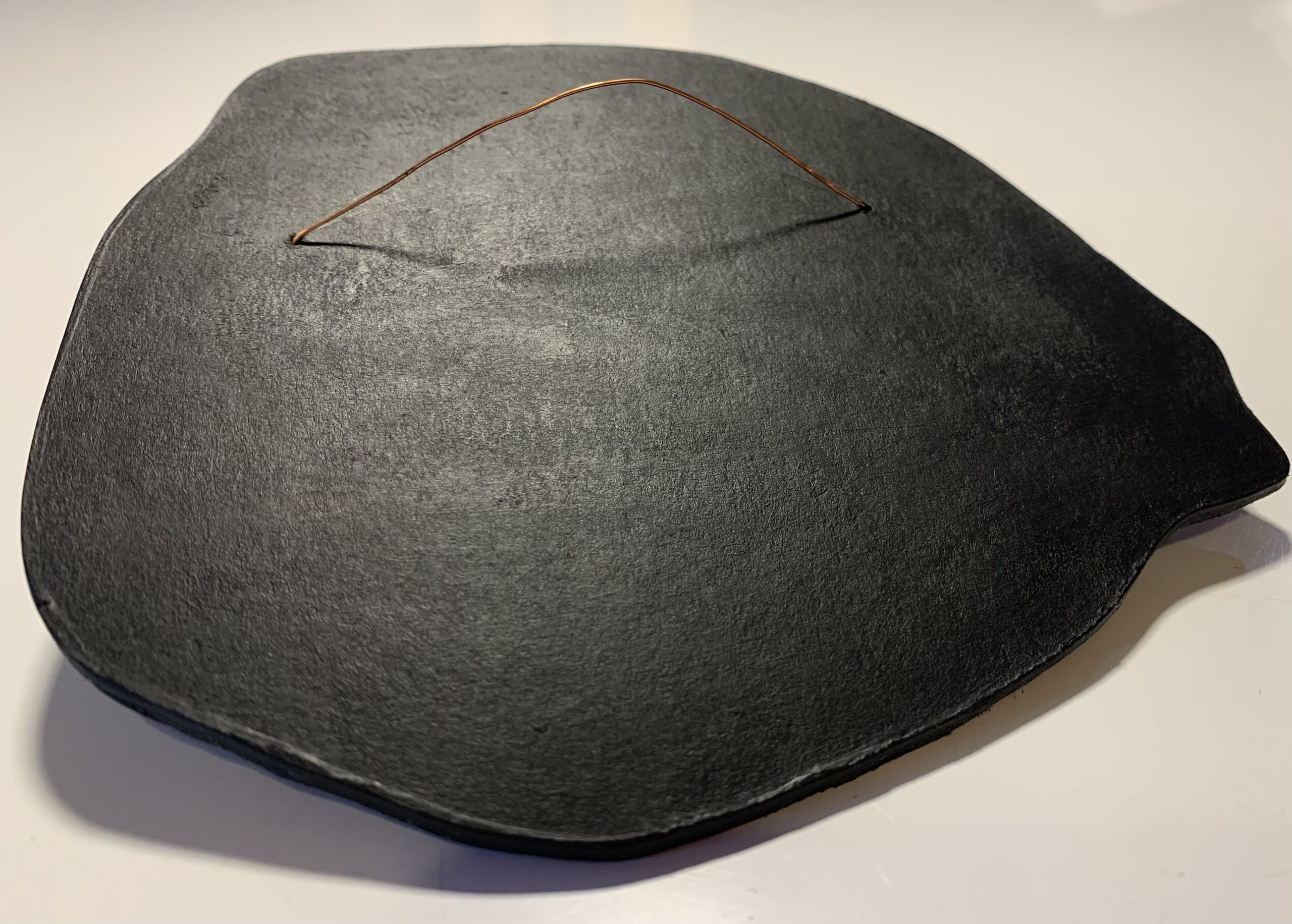 Dos d'une décoration murale en forme de la ville de Paris en émaux sur cuivre cloisonnés. Le dos est peint en noir et possède une attache en fil de cuivre.